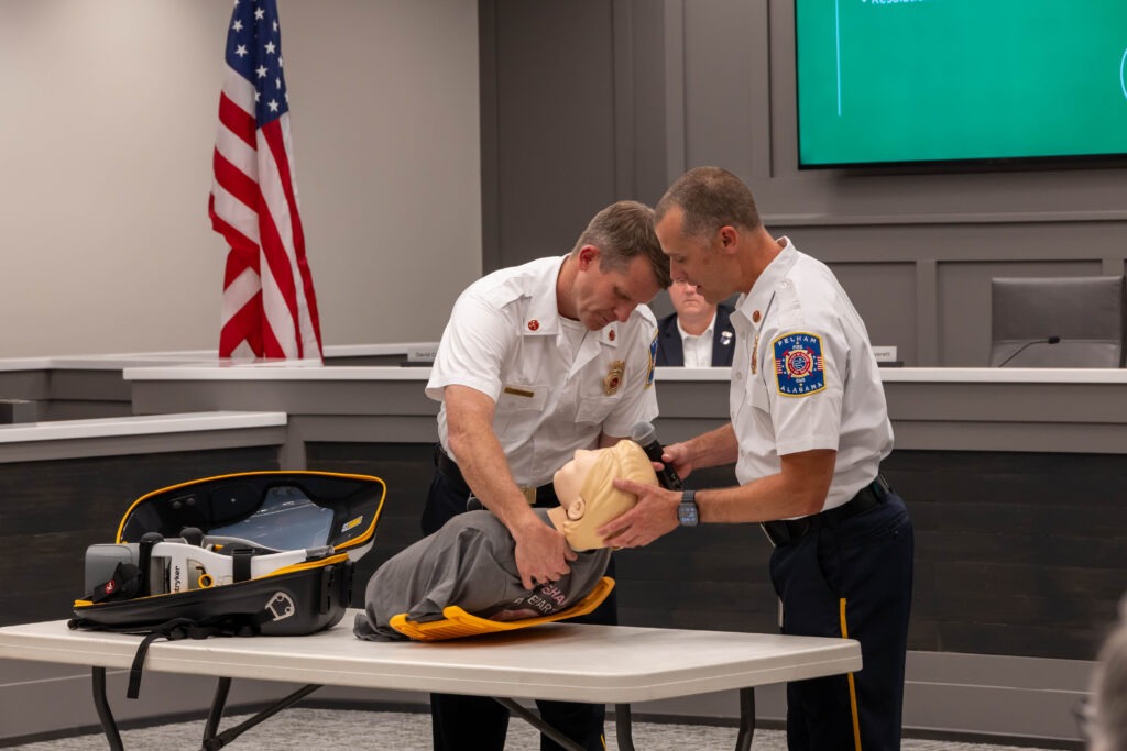 The two firefighters place the CPR dummy in the LUCAS device