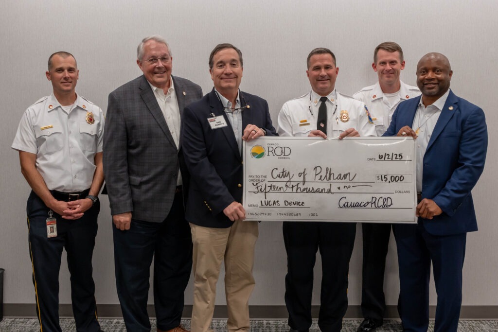 Rep. Mooney, Sen. Roberts, Rep. Paschal, Chief Reid, and two firefighters post with a large check for $15,000 from Cawaco RC&D
