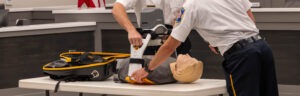 The two firefighters place the CPR dummy in the LUCAS device