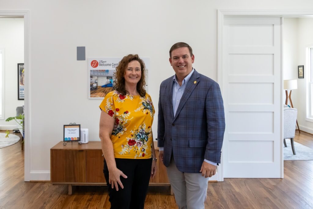 Sen. Matt Woods poses with Joanna Brand at the front of the Jasper Main Street Welcome Center. 