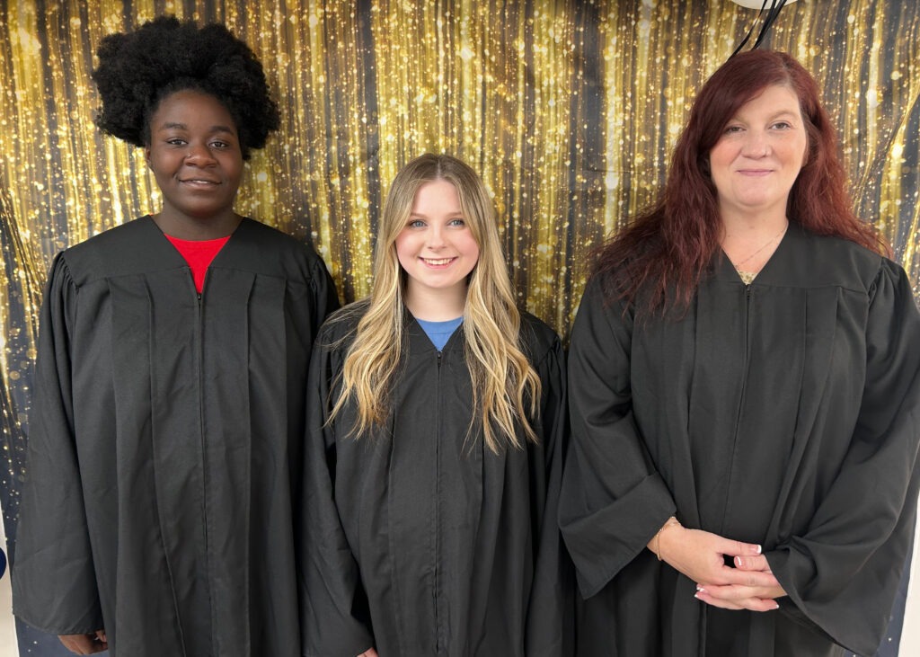 Three mothers in graduation gowns