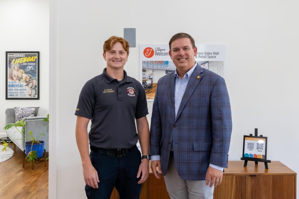 Sen. Matt Woods poses with Lt. Officer K. Hogg at the front of the Jasper Main Street Welcome Center. 
