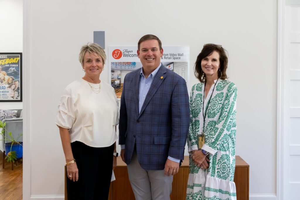Sen. Matt Woods poses with Rita Pilling and Ann Jackson at the front of the Jasper Main Street Welcome Center. 