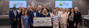 Shelby County attendees gathered at the front of Pelham City Hall's Chambers for the presentation of a large symbolic check