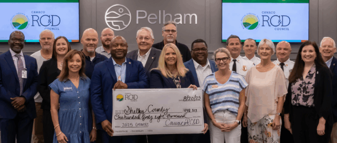 Shelby County attendees gathered at the front of Pelham City Hall's Chambers for the presentation of a large symbolic check