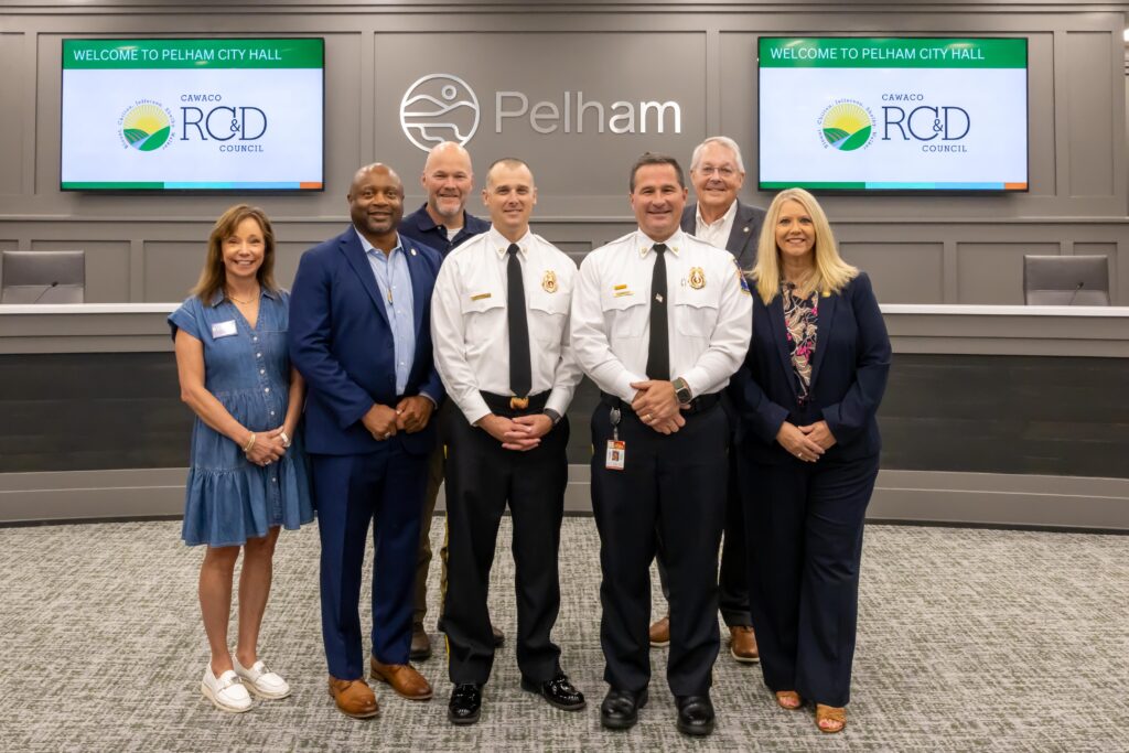 Representatives from City of Pelham Fire Department stand with Shelby County legislators at the grant presentation ceremony, posing at the front of Pelham City Council Chambers