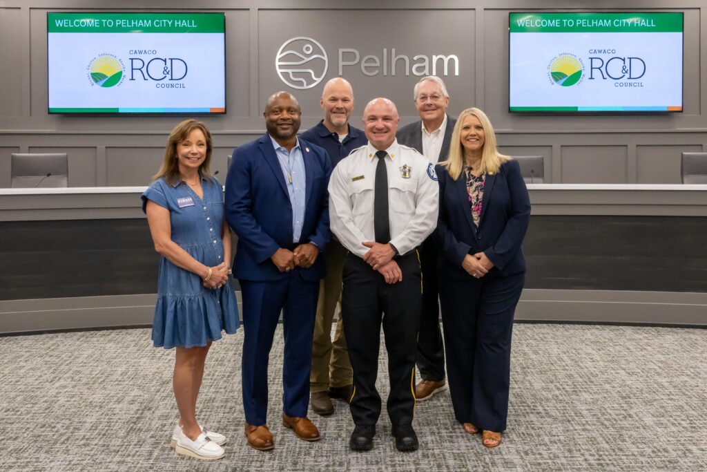 A representative from Helena Fire Department stands with Shelby County legislators at the grant presentation ceremony, posing at the front of Pelham City Council Chambers