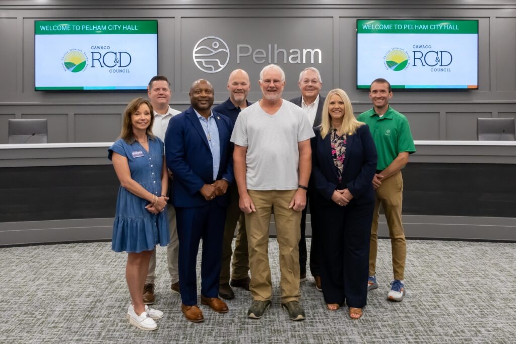 Representatives from Pelham Garden Club stand with Shelby County legislators at the grant presentation ceremony, posing at the front of Pelham City Council Chambers