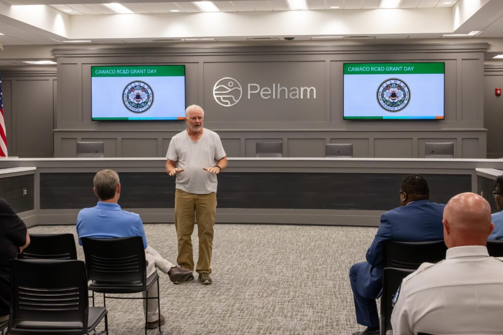 Dennis Stanek stands at the front of the room and talks about Pelham Garden Club's project 