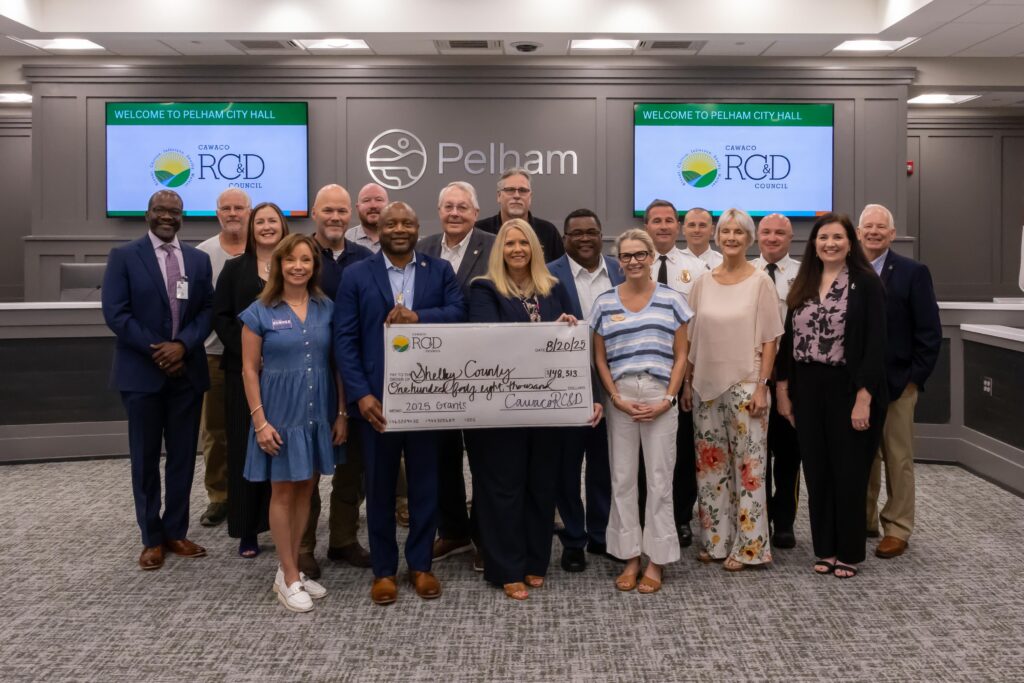 Attendees at the Shelby County Grant Day pose for a picture at the front of the Pelham City Council Chambers. The legislators stand in the middle of the group holding a presentation check made out to Shelby County for $148,313