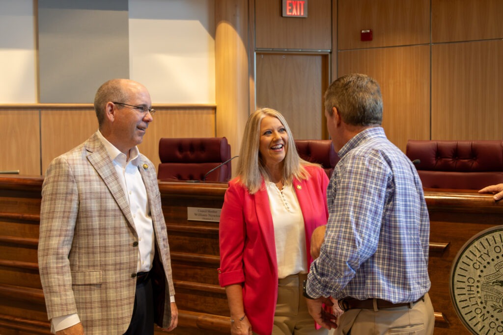 Sen. Clyde Chambliss, Sen. April Weaver, and Clanton Mayor Jeffrey Price in friendly discussion, smiling