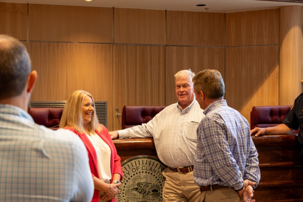Sen. April Weaver, Rep. Van Smith, and Clanton Mayor Jeffery Price in friendly conversation, laughing