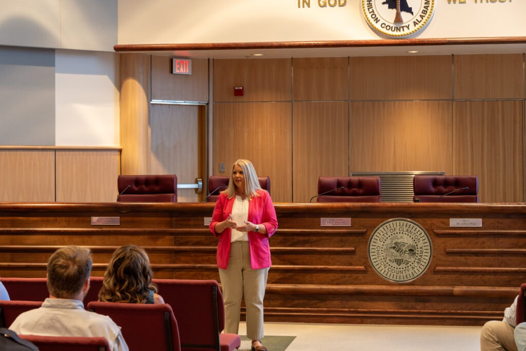 Sen. April Weaver stands at the front of the CIty of Clanton Council Chambers, addressing Chilton County grantees