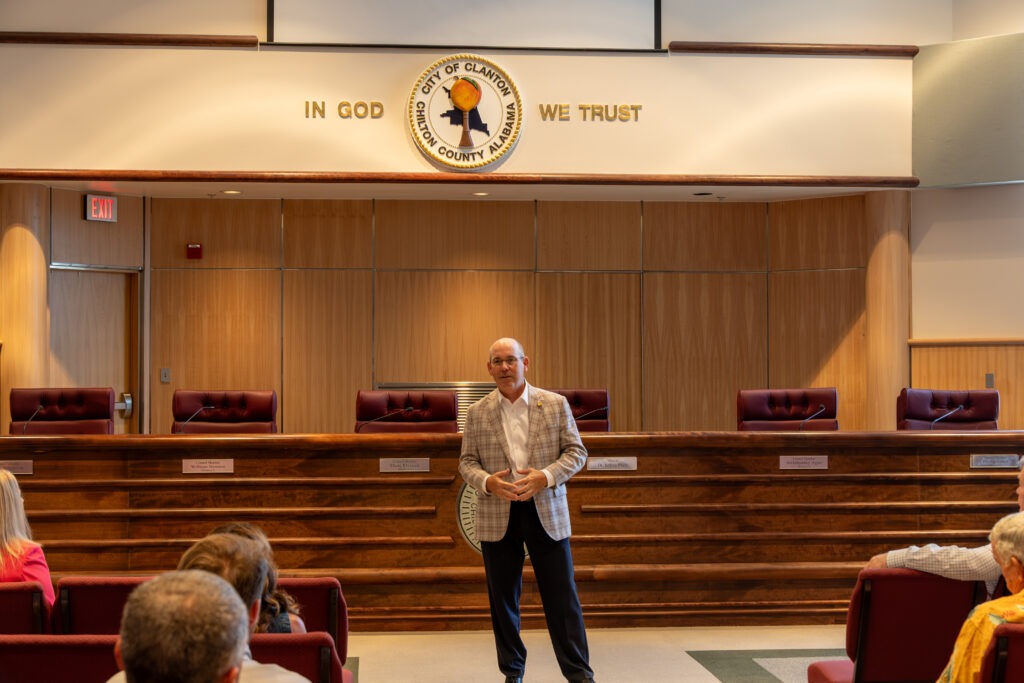 Sen. Clyde Chambliss stands at the front of the CIty of Clanton Council Chambers, addressing Chilton County grantees